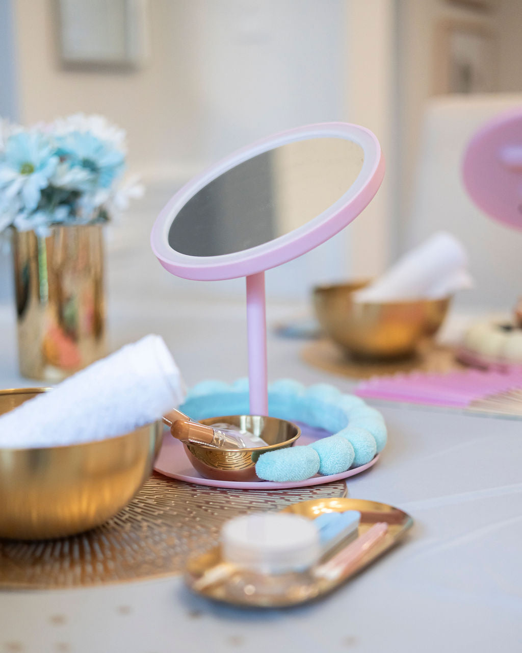 Pink vanity mirror on a table with decorative items