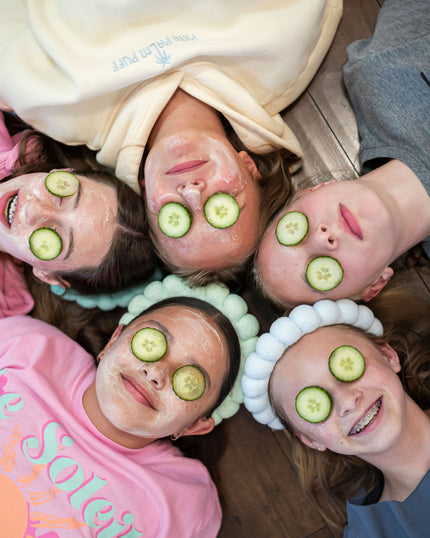 Children with face masks and cucumbers on eyes, lying in a circle
