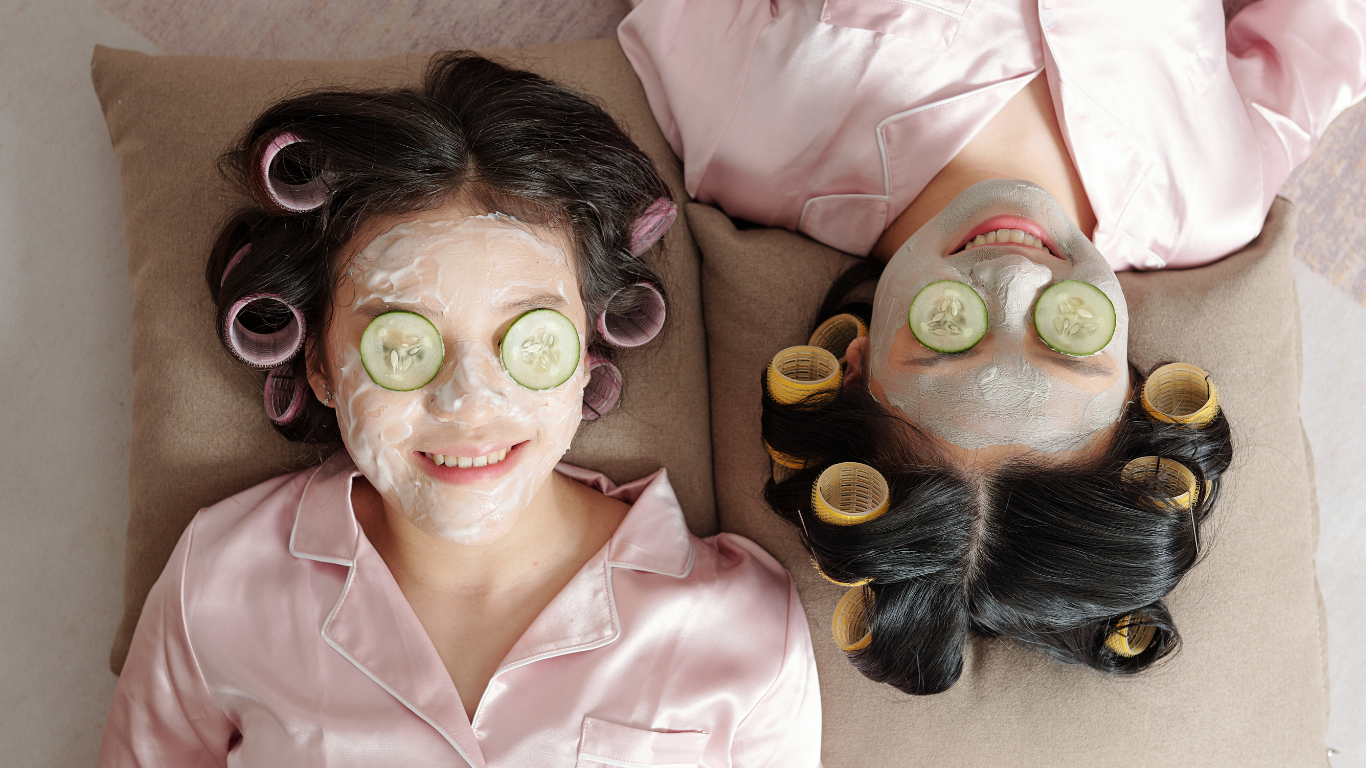 Two Girls with facemasks and cucumbers on their eyes.